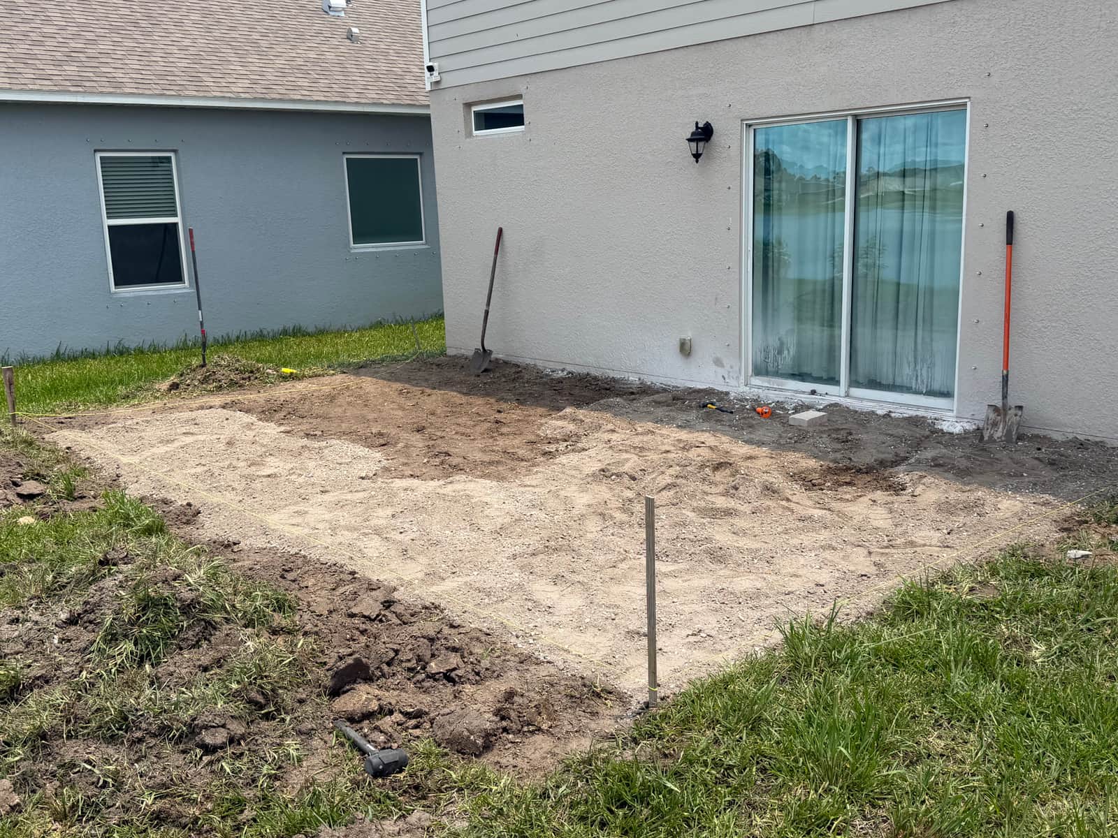 Sand base laid and leveled with string lines marking the patio edges